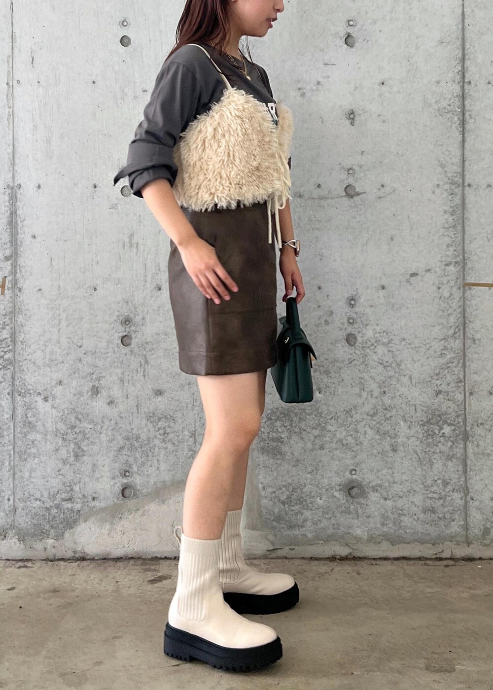 ホワイト系のブーツ、ブラウン系のスカート、ホワイト系のキャミソールを着用したレディースの秋コーディネートの5枚目の写真