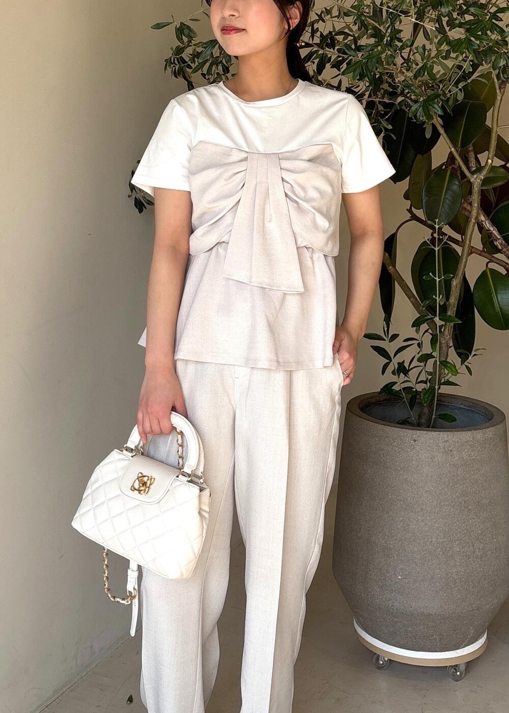 ホワイト系のパンプス、ホワイト系のTシャツ/カットソー、ホワイト系のスラックスを着用したレディースの春コーディネートの7枚目の写真