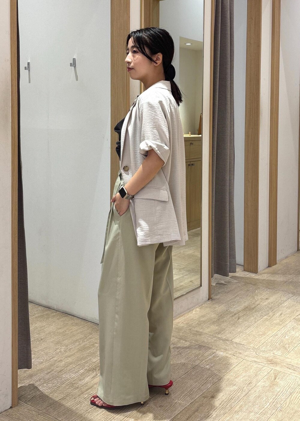 レッド系のサンダル、グレー系のTシャツ/カットソー、グリーン系のスラックスを着用したレディースの夏コーディネートの2枚目の写真