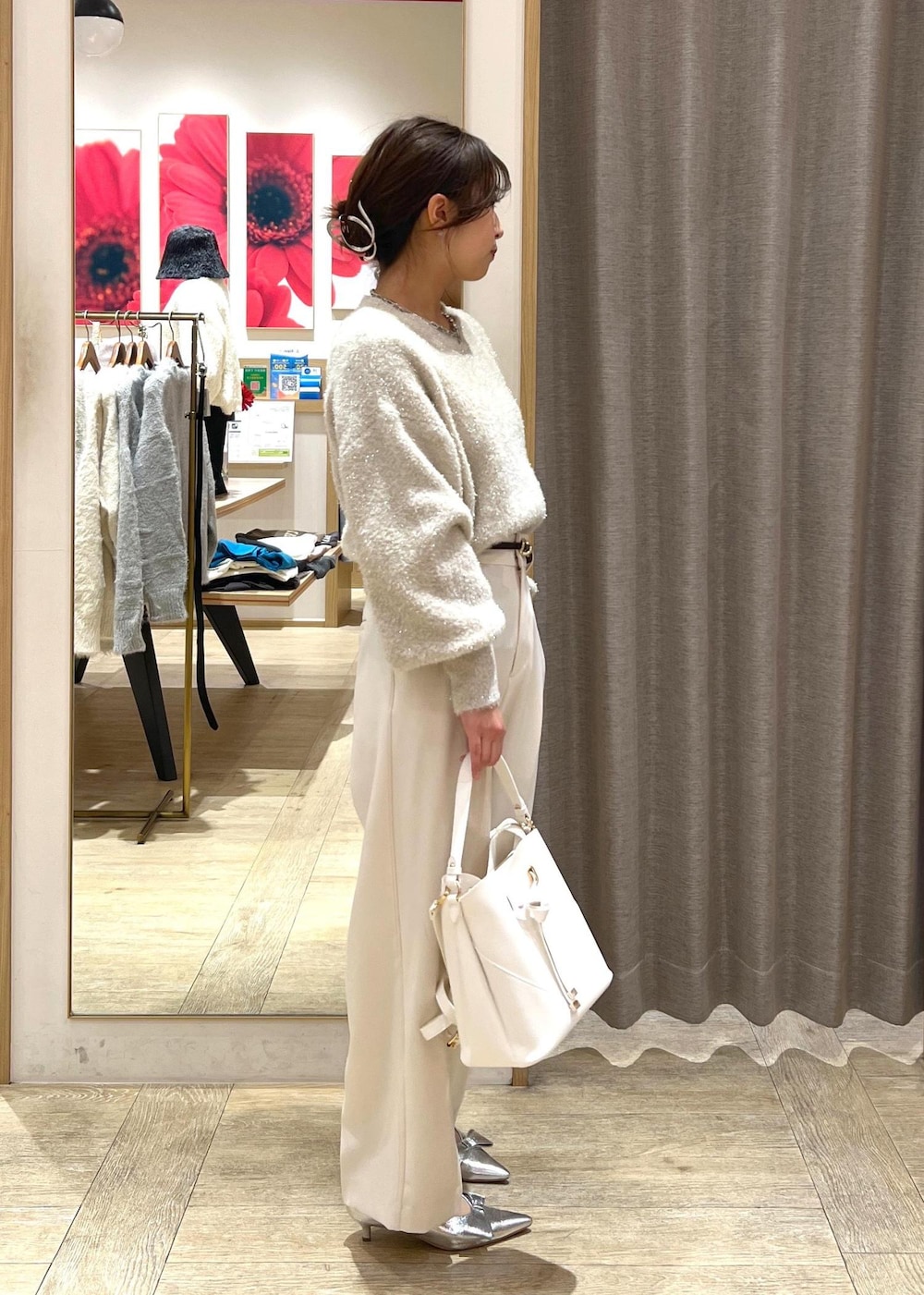 シルバー系のパンプス、ベージュ系のニット/セーター、ホワイト系のスラックスを着用したレディースの冬コーディネートの2枚目の写真