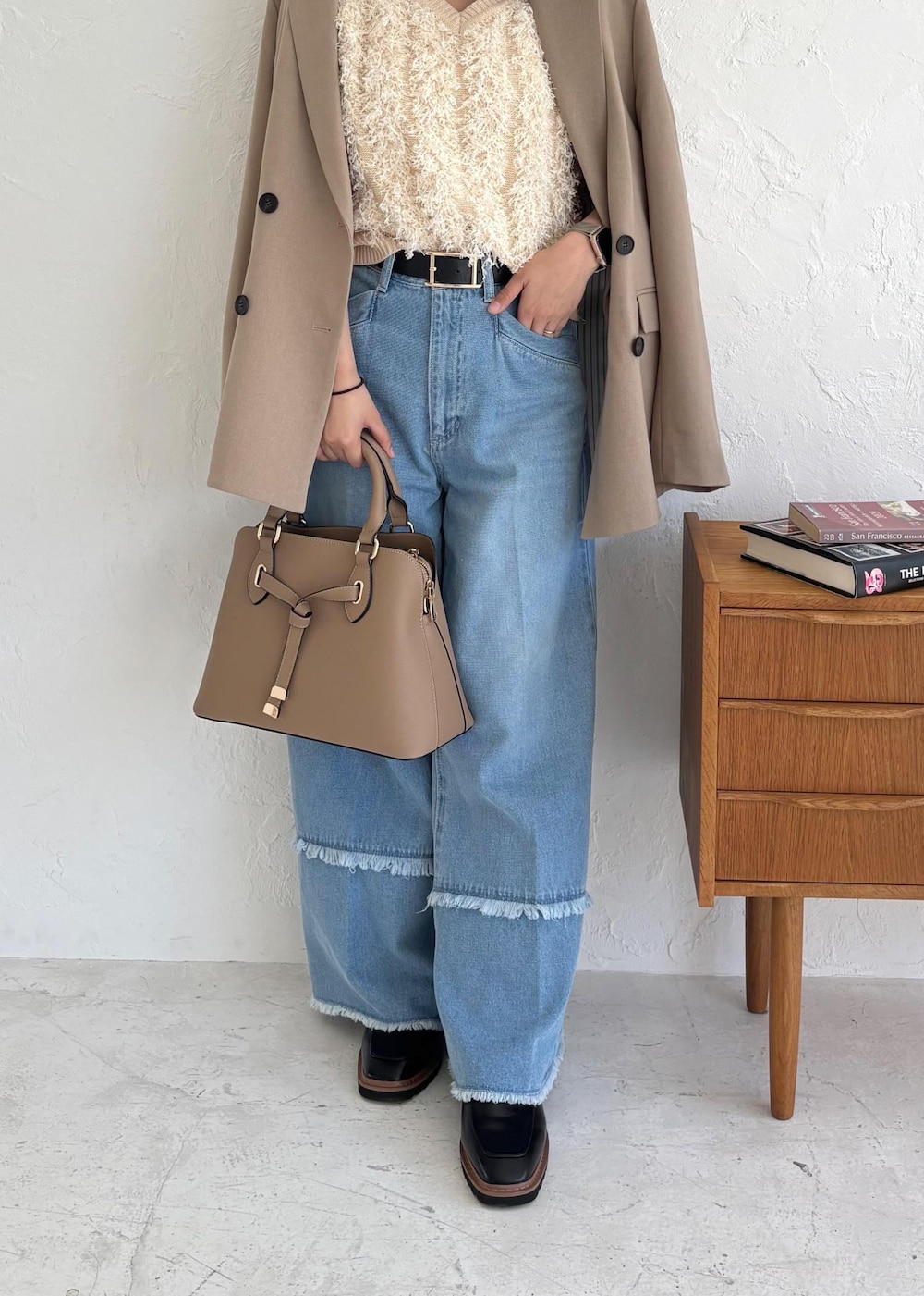 ブラック系のローファー、ホワイト系のベスト、ブルー系のデニムパンツを着用したレディースの夏コーディネートの4枚目の写真