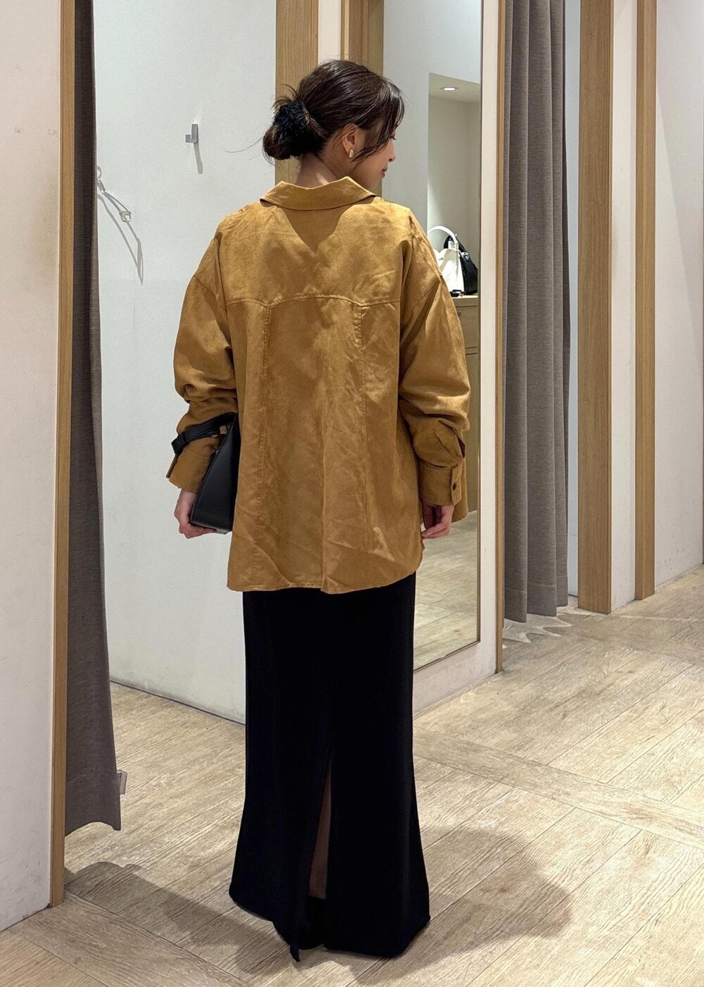 ブラック系のパンプス、ブラック系のスカート、イエロー系のシャツ/ブラウスを着用したレディースの秋コーディネートの3枚目の写真