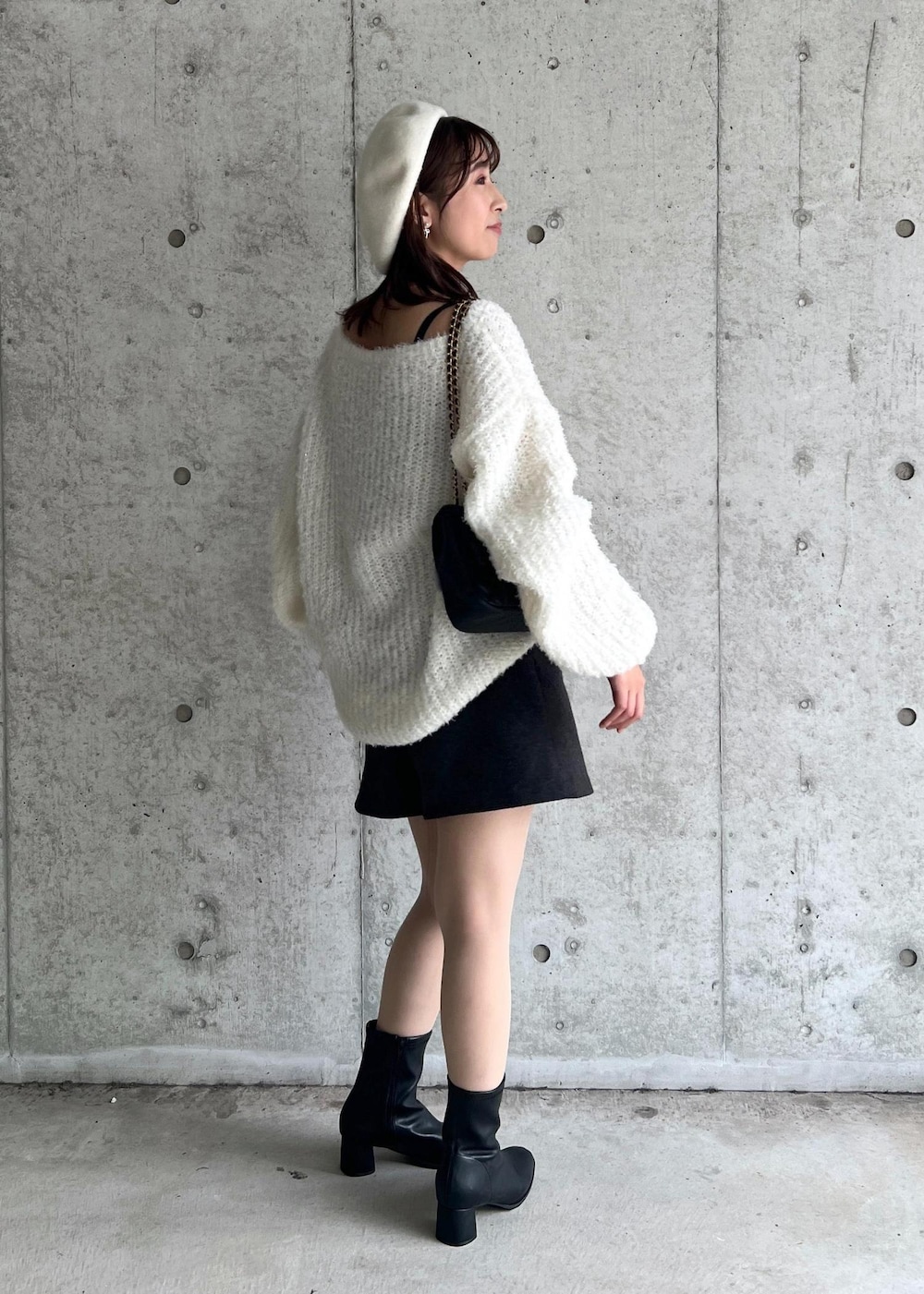 ブラック系のブーツ、ホワイト系のニット/セーター、グレー系のその他パンツを着用したレディースの秋コーディネートの4枚目の写真