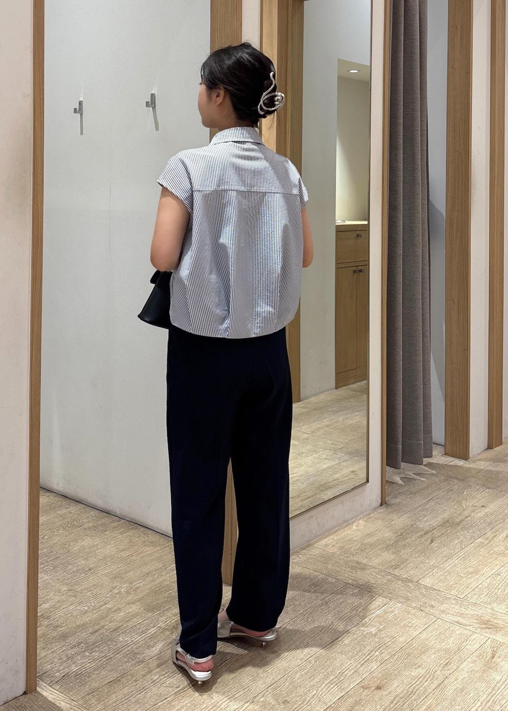 ブラック系のショルダーバッグ、シルバー系のパンプス、ブラック系のシャツ/ブラウスを着用したレディースの夏コーディネートの3枚目の写真