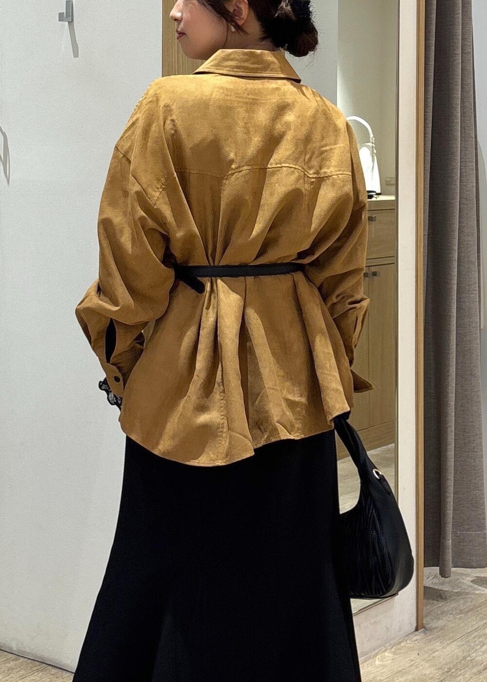 ブラック系のスカート、ブラック系のTシャツ/カットソー、ブラック系のハンドバッグを着用したレディースの秋コーディネートの7枚目の写真