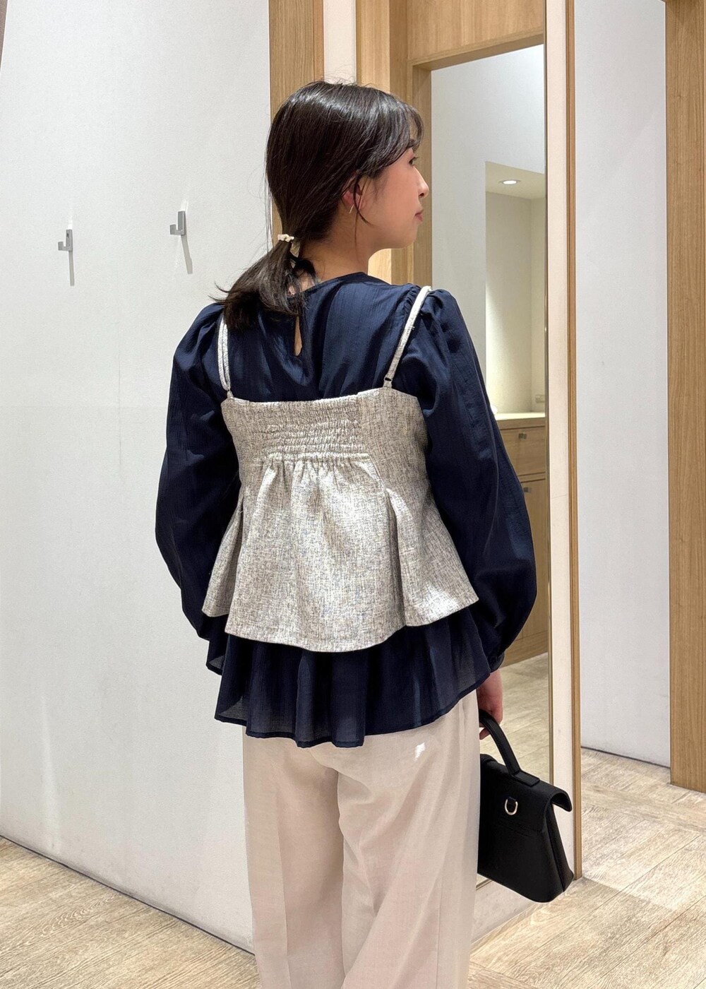 ブラック系のショルダーバッグ、ブルー系のシャツ/ブラウス、シルバー系のパンプスを着用したレディースの春コーディネートの8枚目の写真