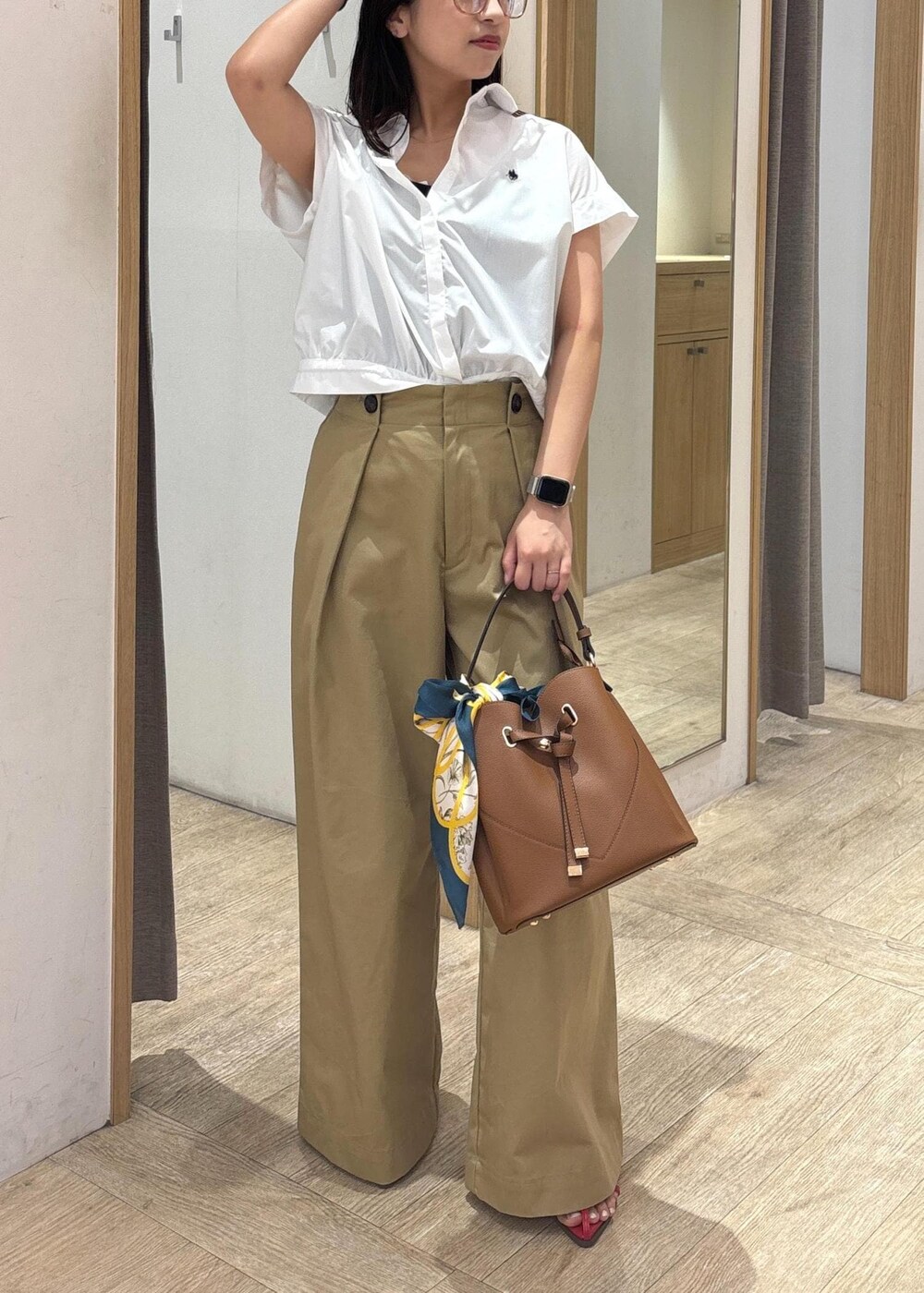 ブラウン系のショルダーバッグ、レッド系のサンダル、ホワイト系のシャツ/ブラウスを着用したレディースの夏コーディネートの7枚目の写真