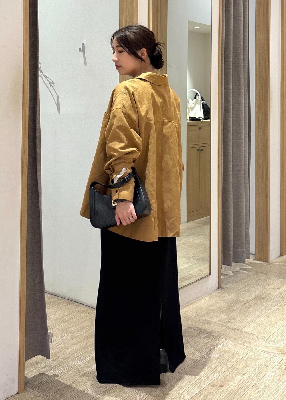 ブラック系のパンプス、ブラック系のスカート、イエロー系のシャツ/ブラウスを着用したレディースの秋コーディネートの4枚目の写真