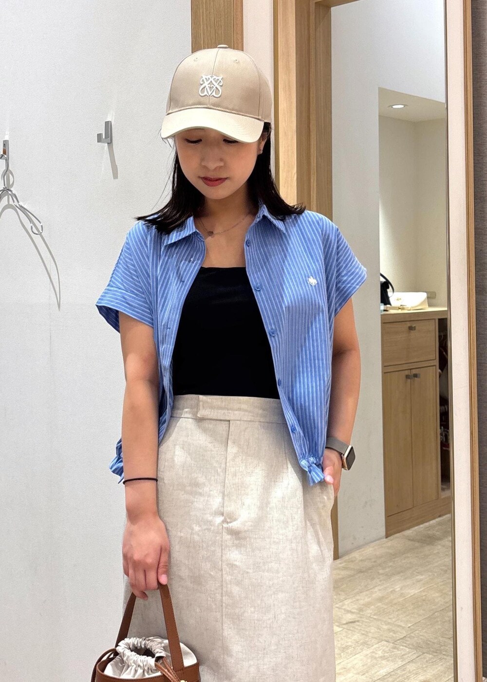 ブラック系のサンダル、ホワイト系のスカート、ブルー系のシャツ/ブラウスを着用したレディースの夏コーディネートの5枚目の写真