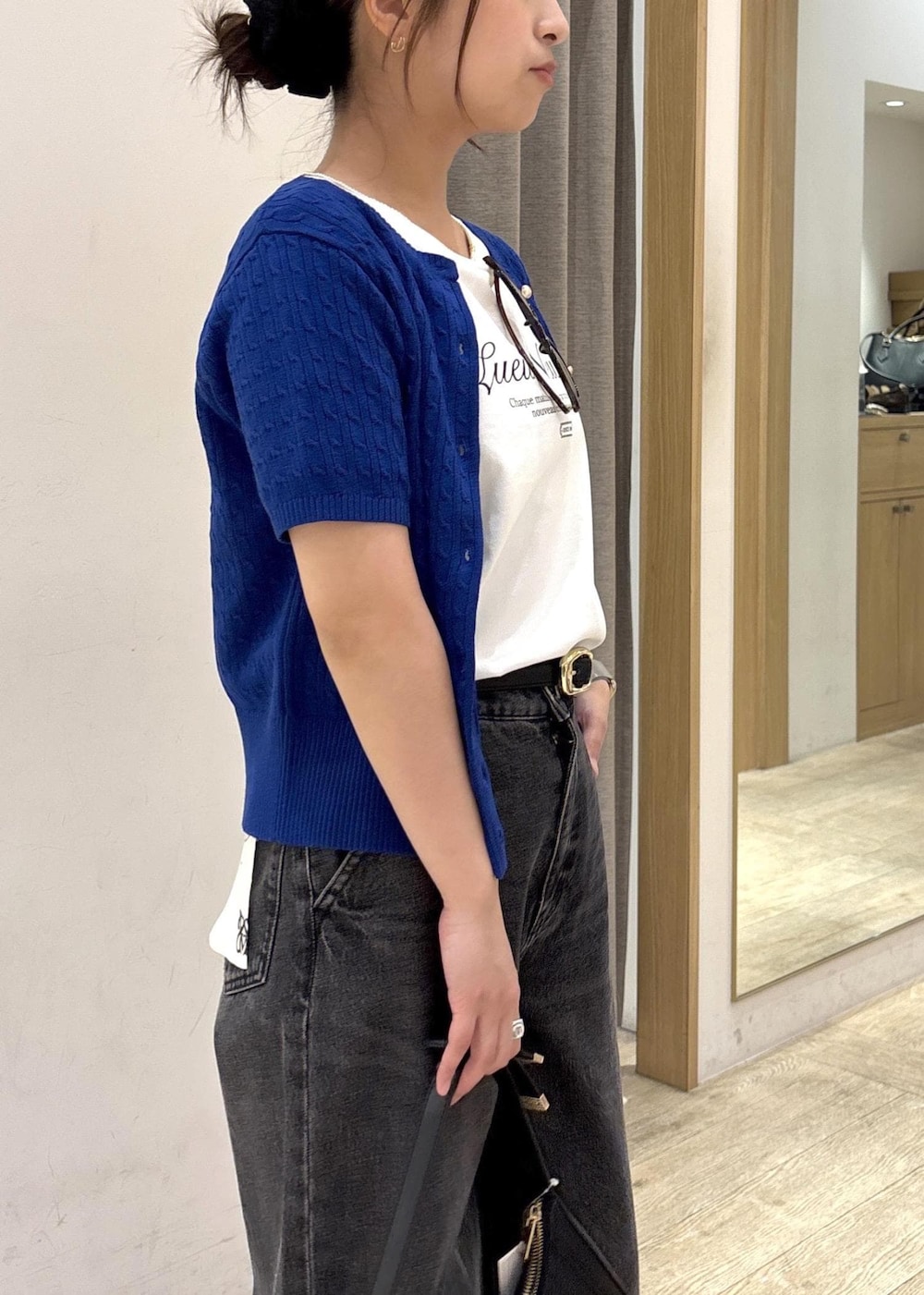 ブラック系のショルダーバッグ、ブラック系のデニムパンツ、ホワイト系のTシャツ/カットソーを着用したレディースの春コーディネートの7枚目の写真