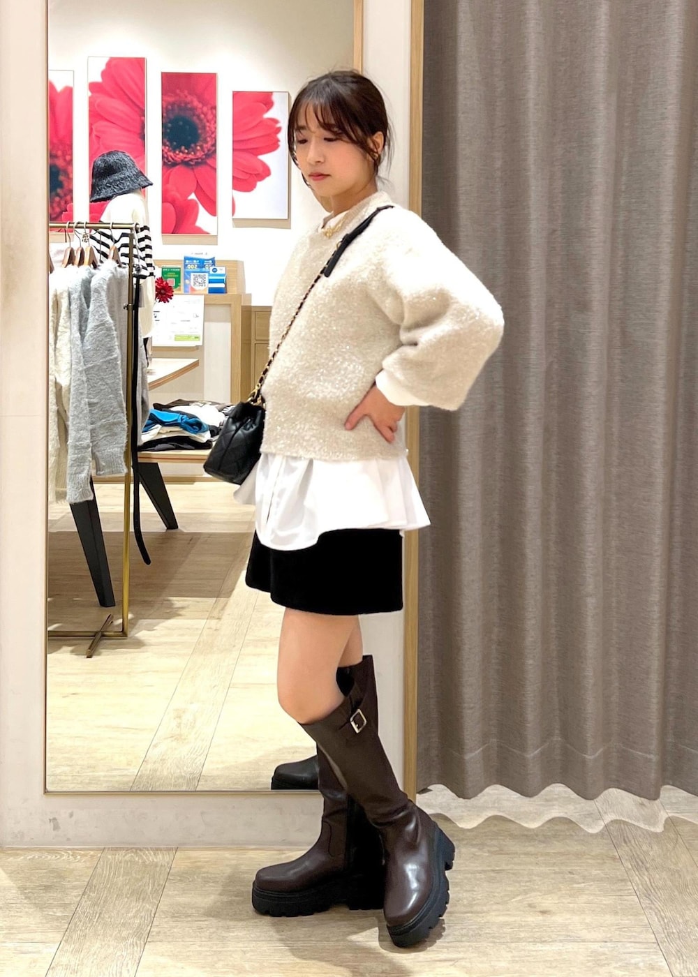 ブラウン系のブーツ、ホワイト系のシャツ/ブラウス、ベージュ系のニット/セーターを着用したレディースの冬コーディネートの3枚目の写真