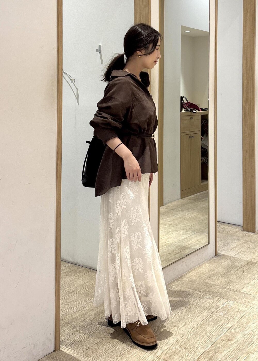 ブラック系のショルダーバッグ、ベージュ系のローファー、ブラウン系のシャツ/ブラウスを着用したレディースの秋コーディネートの4枚目の写真