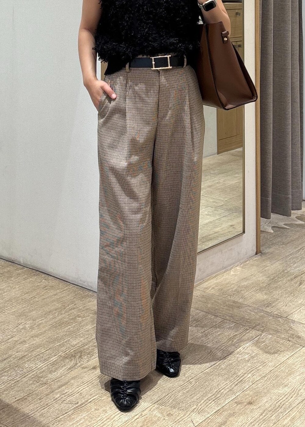 ブラック系のパンプス、ブラック系のベスト、ベージュ系のスラックスを着用したレディースの秋コーディネートの8枚目の写真