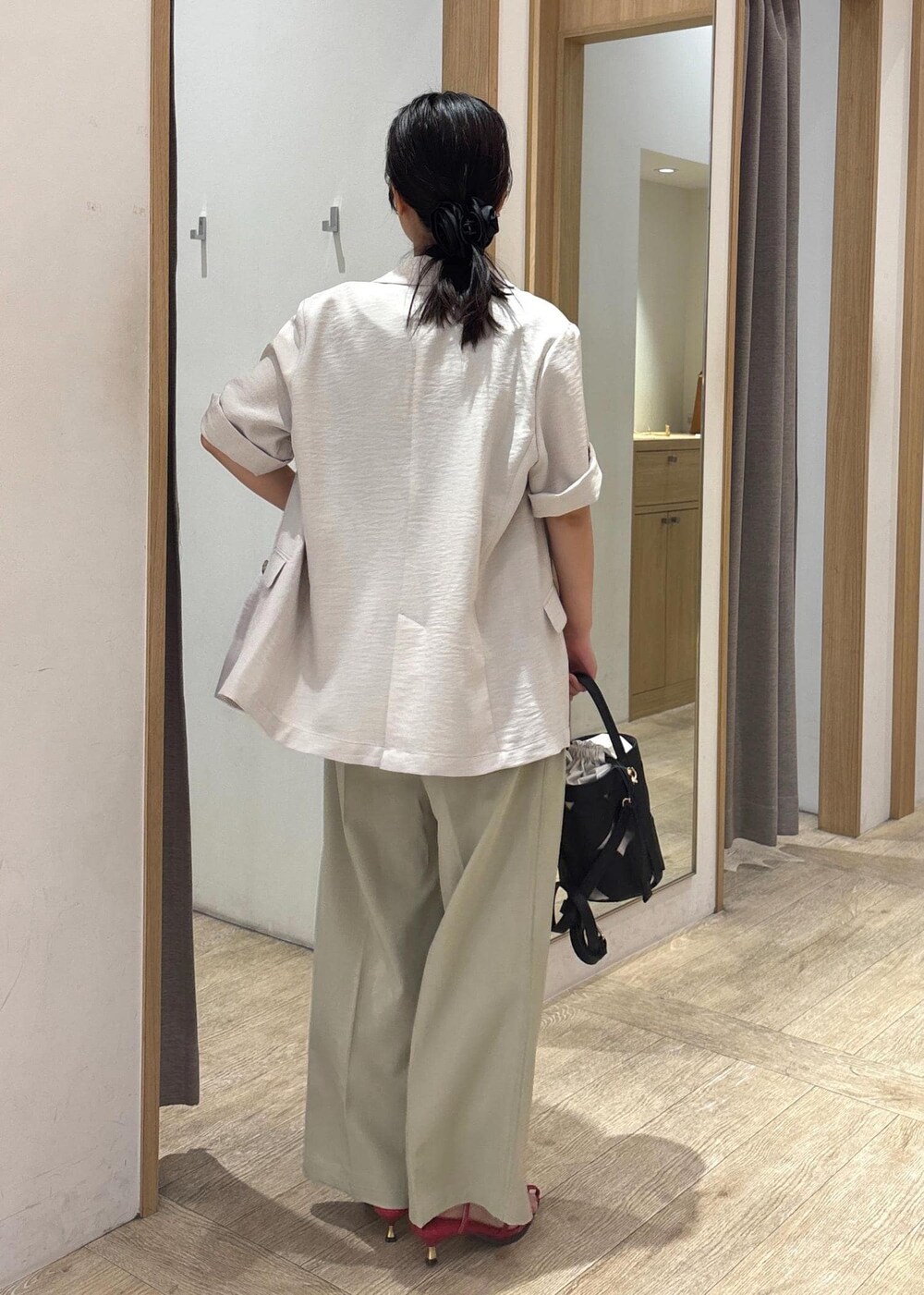 レッド系のサンダル、グレー系のTシャツ/カットソー、グリーン系のスラックスを着用したレディースの夏コーディネートの3枚目の写真