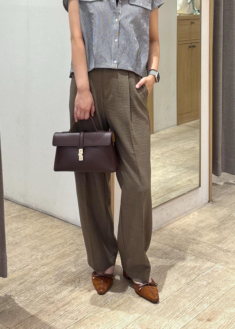 ブラウン系のショルダーバッグ、グリーン系のスラックス、ブラック系のシャツ/ブラウスを着用したレディースの夏コーディネートの8枚目の写真