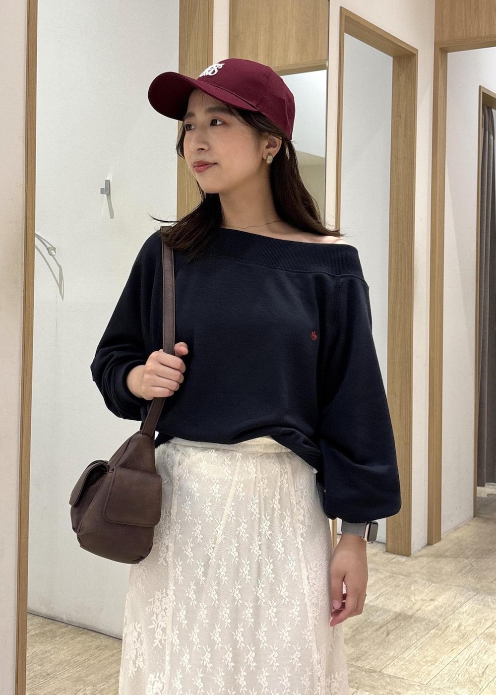 ブラウン系のショルダーバッグ、ベージュ系のローファー、ホワイト系のスカートを着用したレディースの秋コーディネートの6枚目の写真