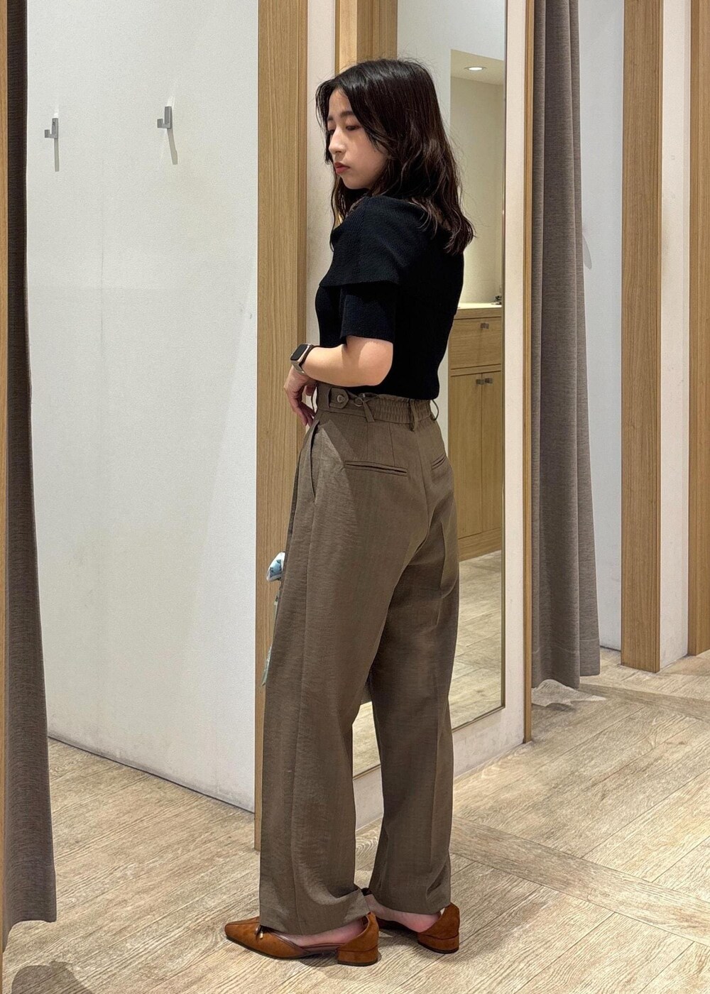 ホワイト系のショルダーバッグ、グリーン系のスラックス、ブラック系のニット/セーターを着用したレディースの夏コーディネートの4枚目の写真