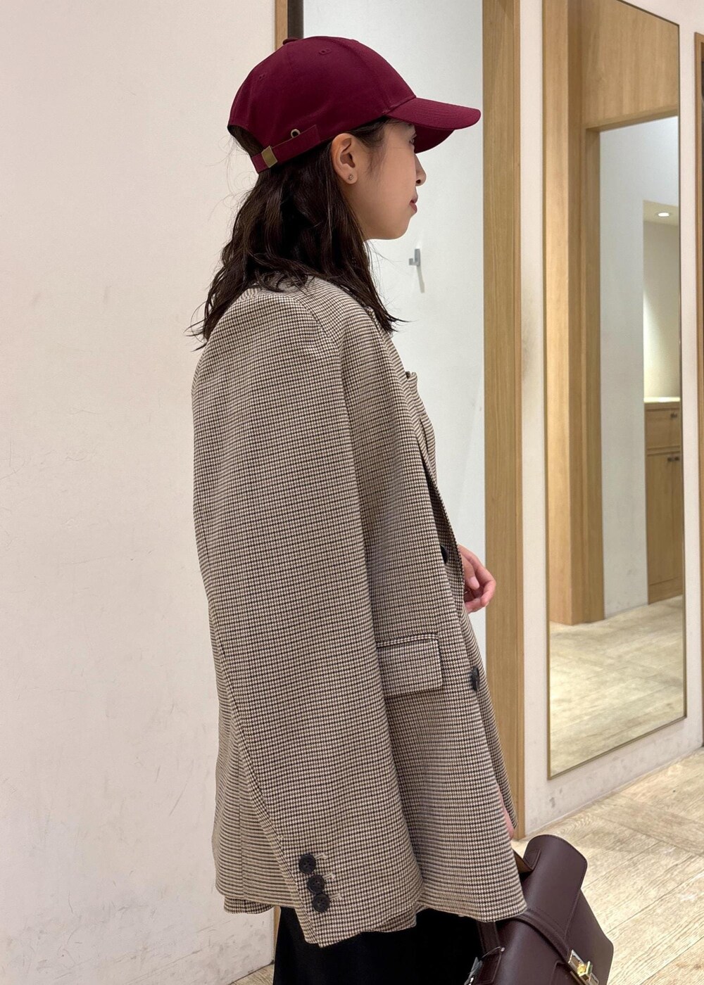 ブラウン系のショルダーバッグ、ベージュ系のテーラードジャケット、ベージュ系のキャミソールを着用したレディースの秋コーディネートの6枚目の写真