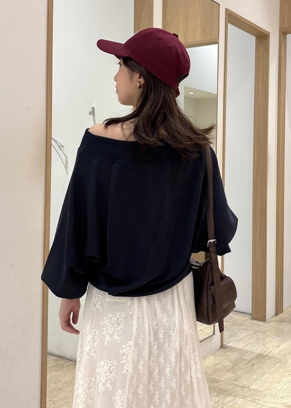 ブラウン系のショルダーバッグ、ベージュ系のローファー、ホワイト系のスカートを着用したレディースの秋コーディネートの8枚目の写真