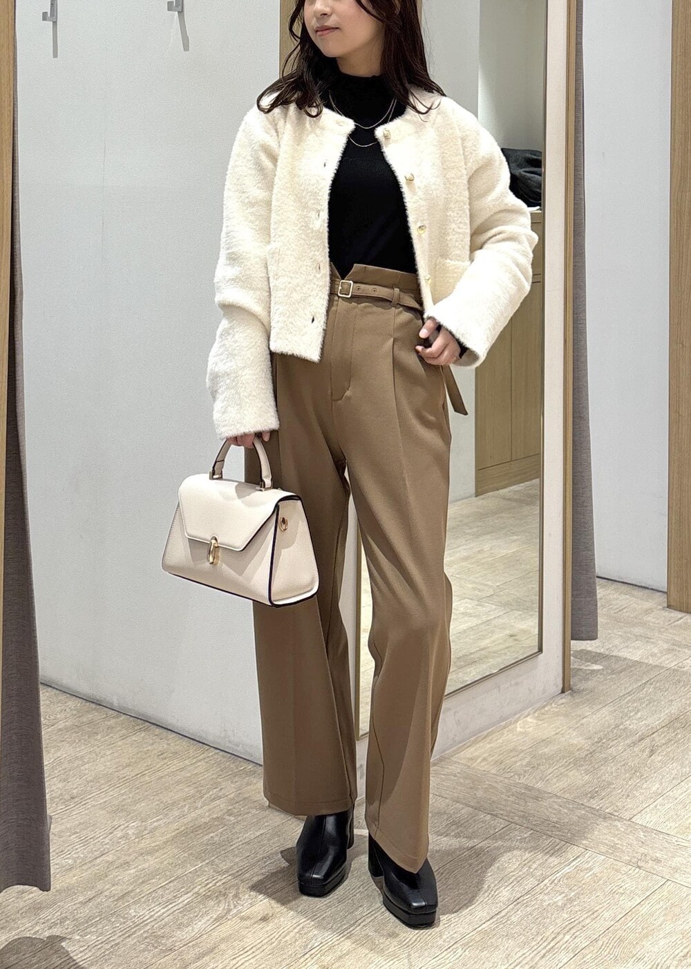 ホワイト系のカーディガン/ボレロ、ブラック系のTシャツ/カットソー、ブラック系のブーツを着用したレディースの秋コーディネートの9枚目の写真