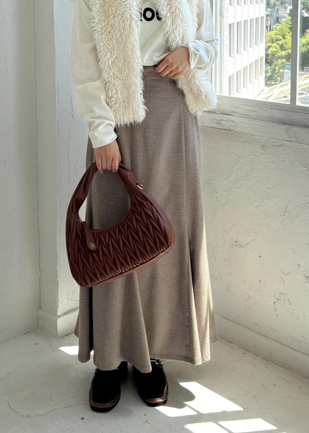 ブラック系のローファー、ベージュ系のスカート、ホワイト系のTシャツ/カットソーを着用したレディースの夏コーディネートの8枚目の写真