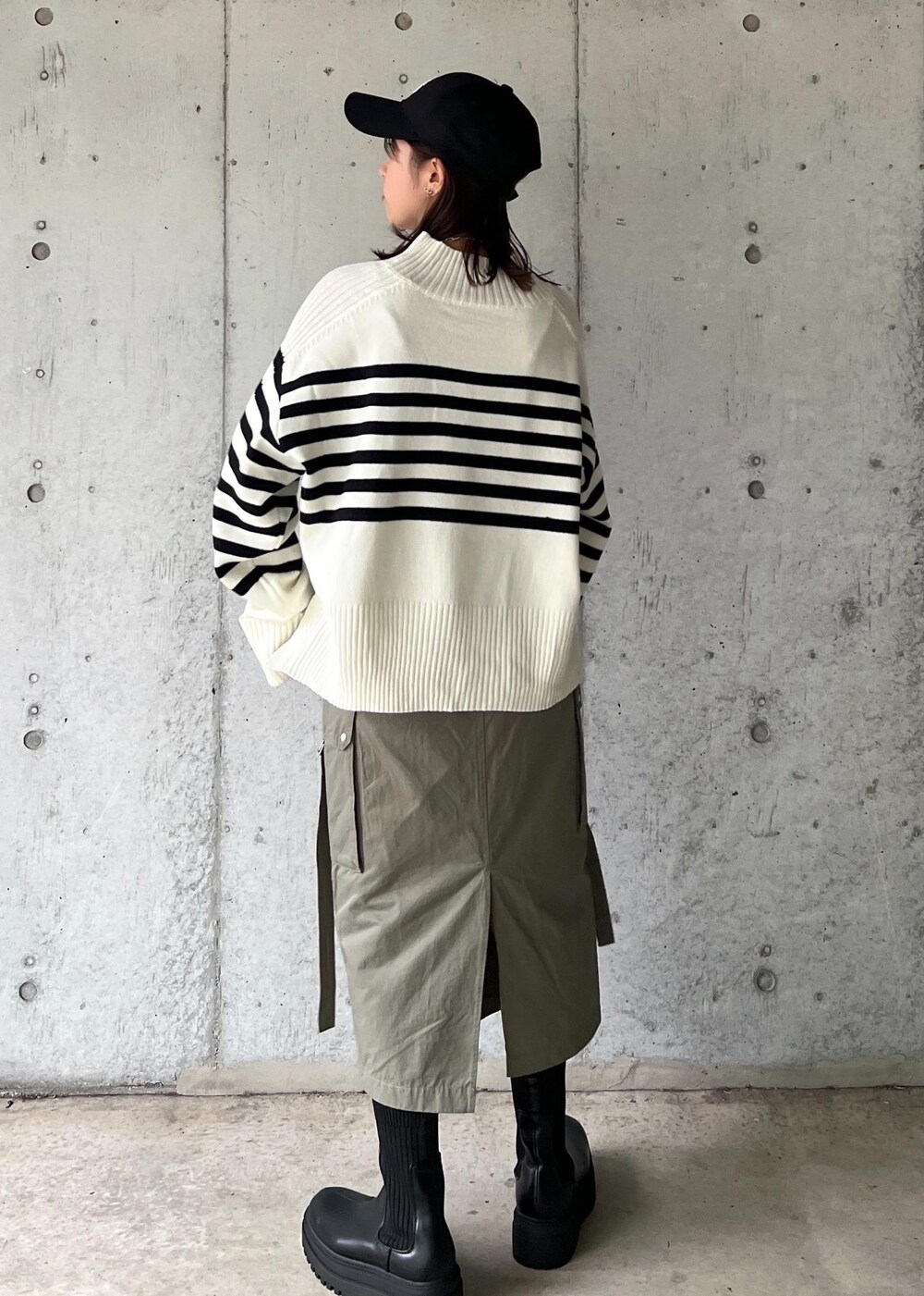 ブラック系のブーツ、グリーン系のスカート、ホワイト系のニット/セーターを着用したレディースの秋コーディネートの5枚目の写真