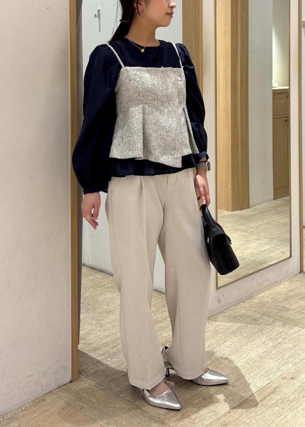 ブラック系のショルダーバッグ、ブルー系のシャツ/ブラウス、シルバー系のパンプスを着用したレディースの春コーディネートの2枚目の写真