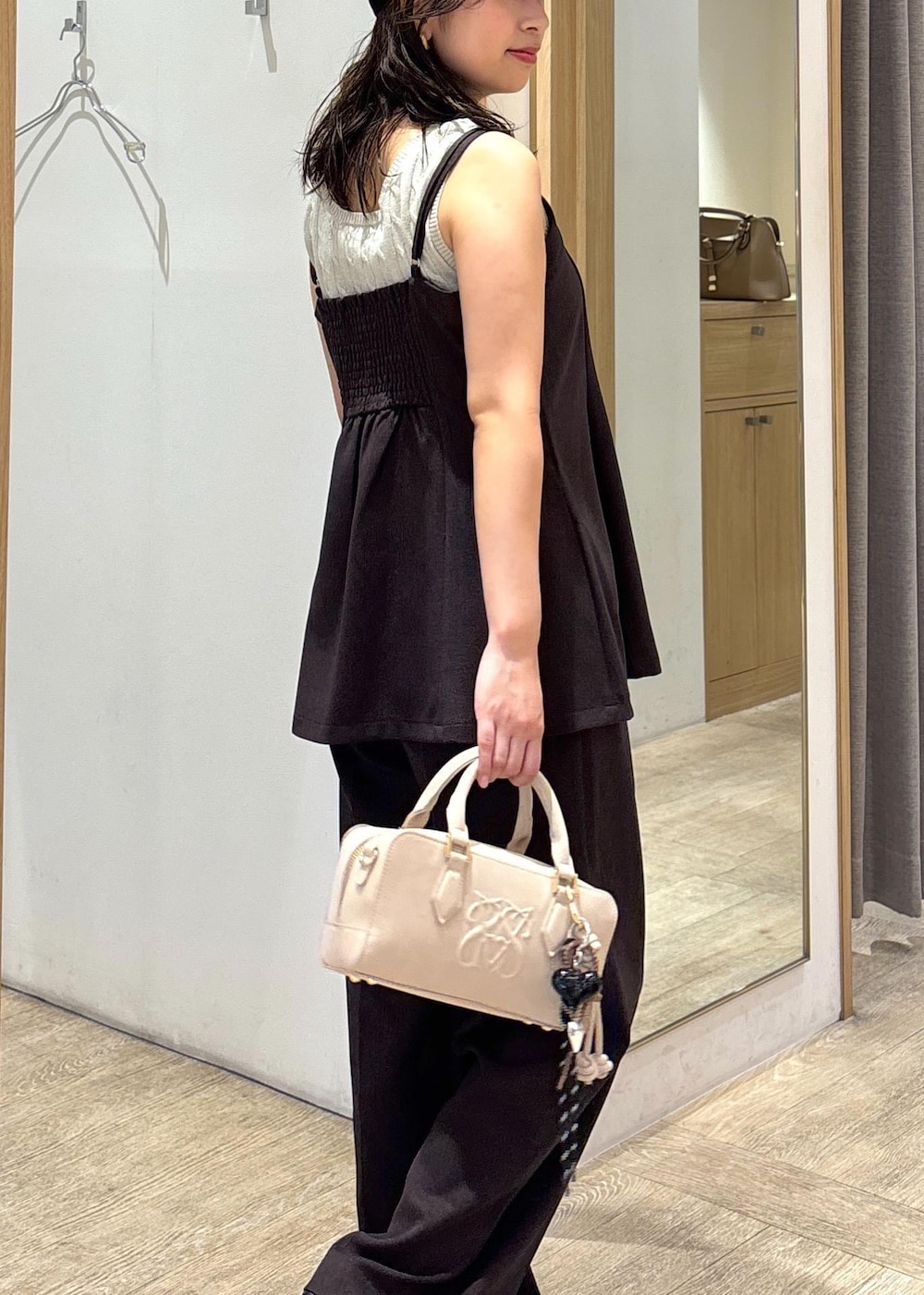 ベージュ系のボストンバッグ、ブラウン系のスラックス、ブラウン系のキャミソールを着用したレディースの秋コーディネートの7枚目の写真