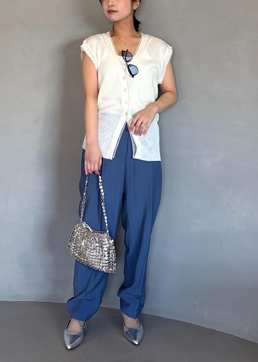 シルバー系のパンプス、ブルー系のその他パンツ、ホワイト系のベストを着用したレディースの春コーディネートの2枚目の写真