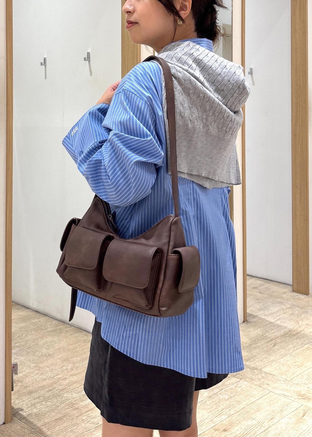 ブラック系のブーツ、ブルー系のシャツ/ブラウス、グレー系のカーディガン/ボレロを着用したレディースの秋コーディネートの8枚目の写真