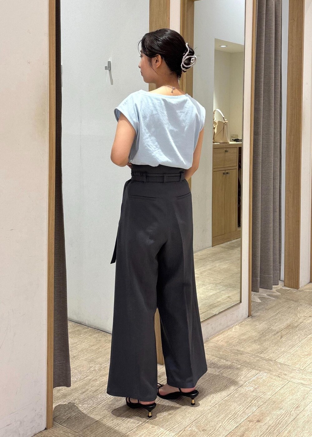 ブラック系のサンダル、ブルー系のTシャツ/カットソー、グレー系のスラックスを着用したレディースの夏コーディネートの4枚目の写真