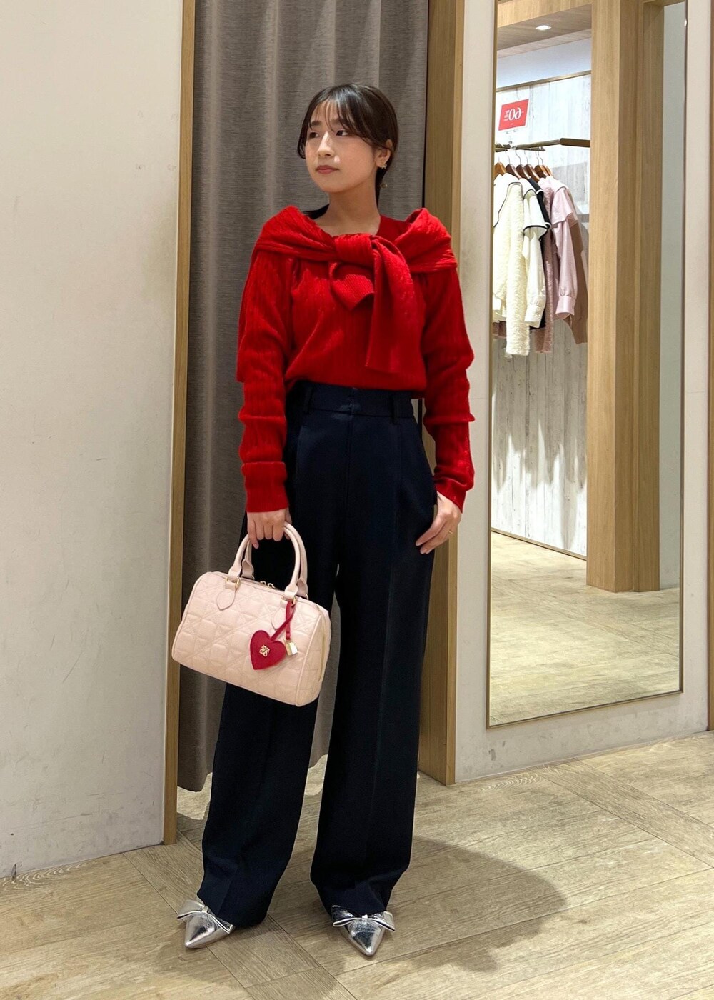 シルバー系のパンプス、レッド系のカーディガン/ボレロ、レッド系のニット/セーターを着用したレディースの冬コーディネートの2枚目の写真