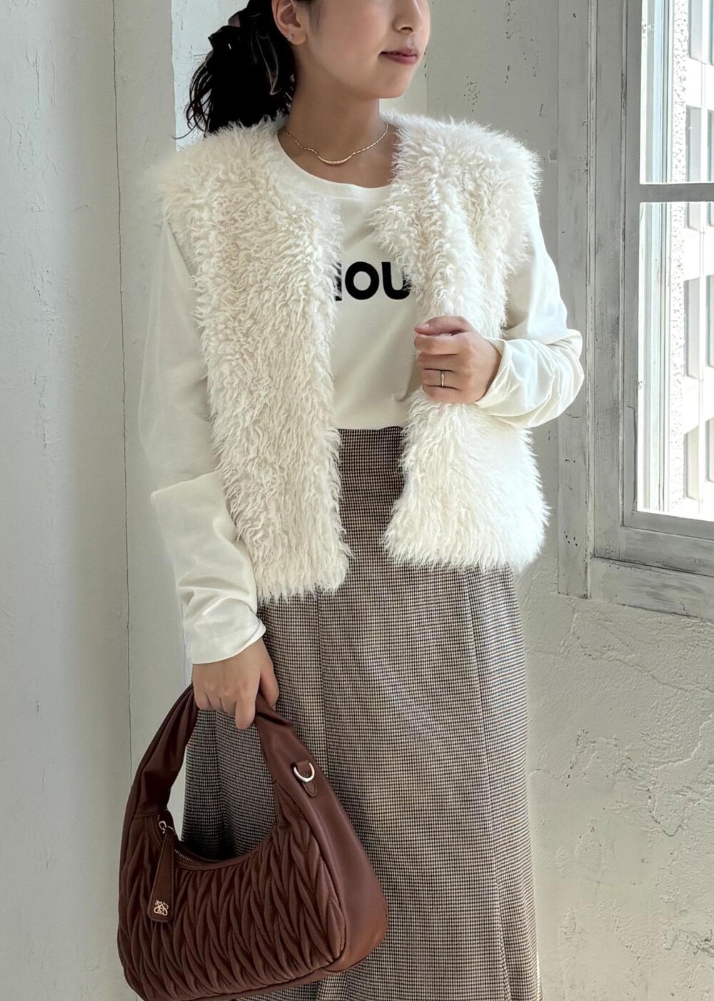 ブラック系のローファー、ベージュ系のスカート、ホワイト系のTシャツ/カットソーを着用したレディースの夏コーディネートの6枚目の写真