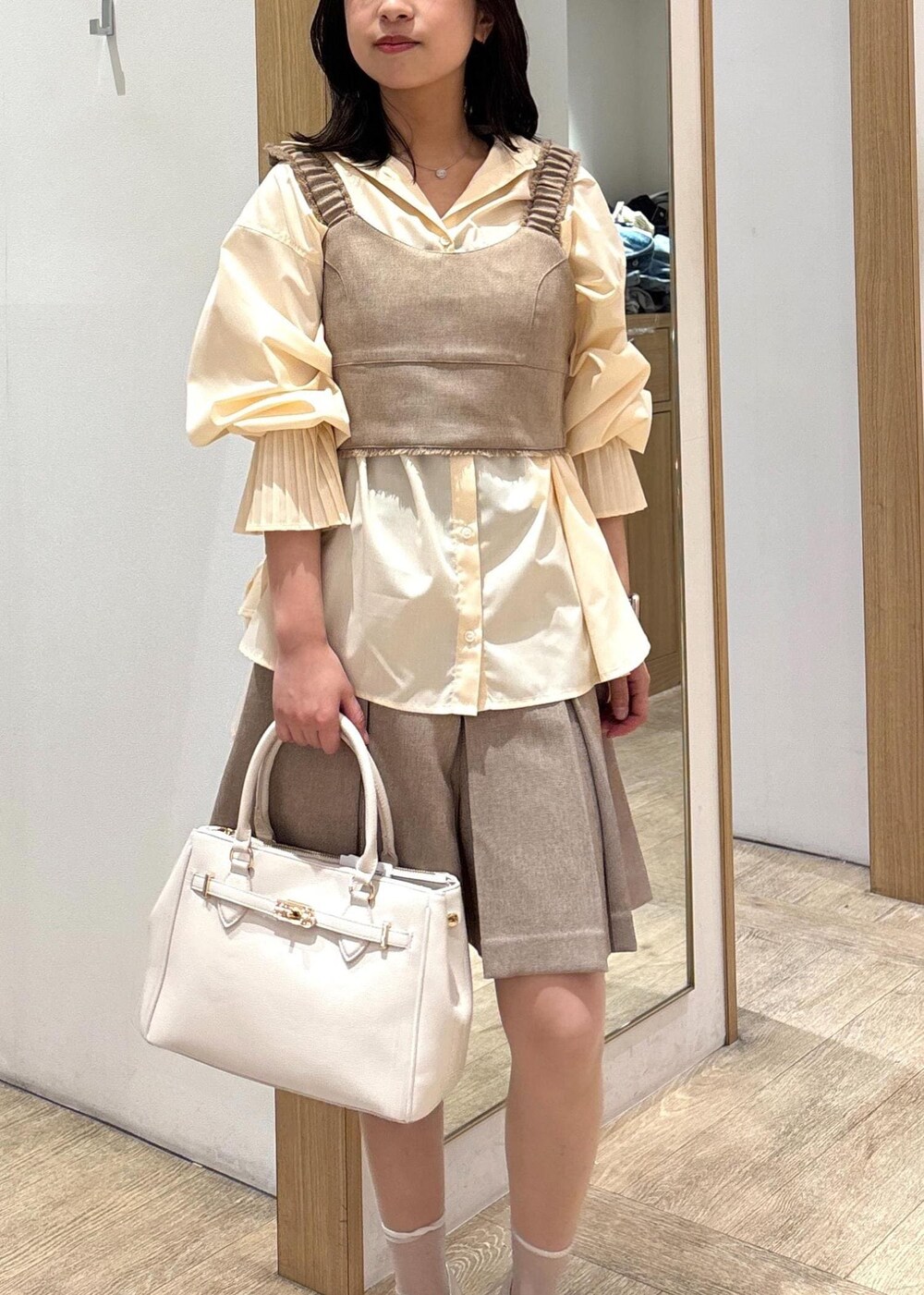 ホワイト系のショルダーバッグ、イエロー系のその他パンツ、イエロー系のベストを着用したレディースの春コーディネートの4枚目の写真