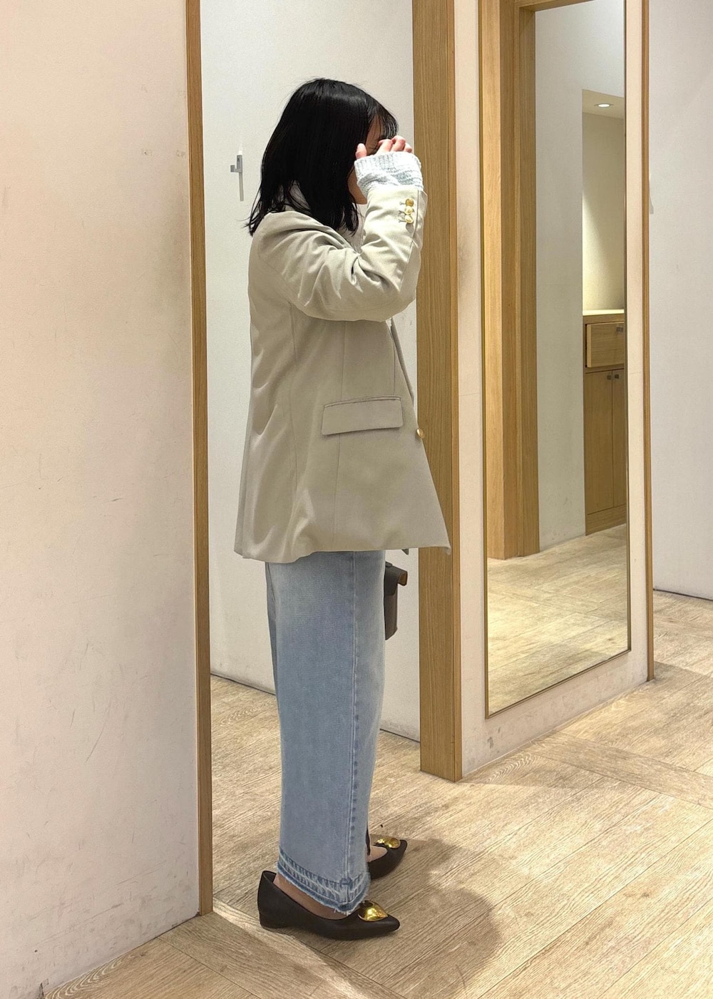 グレー系のショルダーバッグ、ブラック系のバレエシューズ、ブルー系のデニムスカートを着用したレディースの冬コーディネートの3枚目の写真