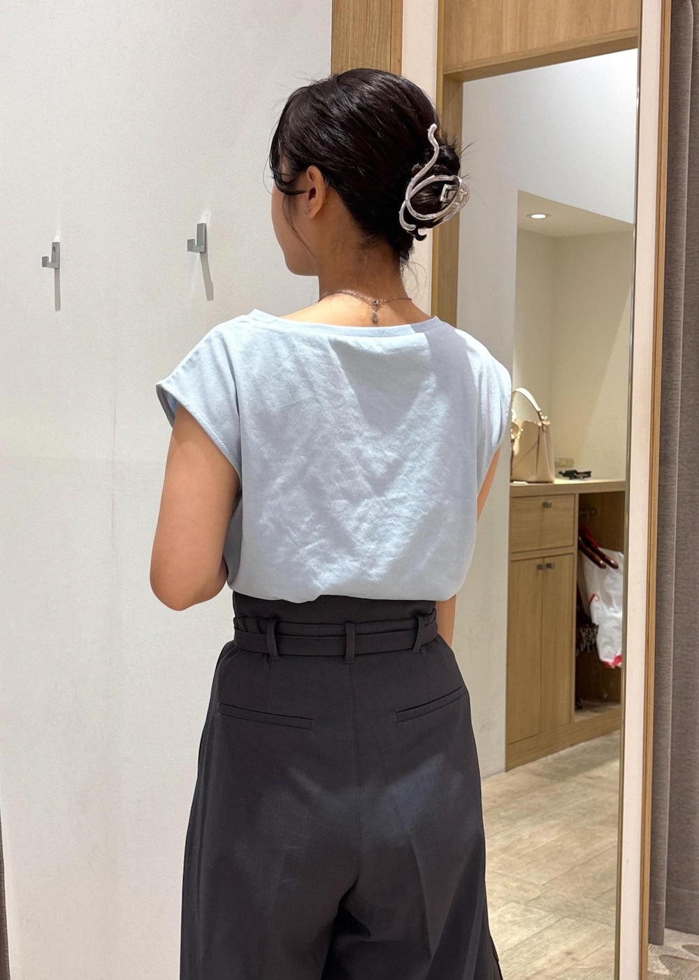 ブラック系のサンダル、ブルー系のTシャツ/カットソー、グレー系のスラックスを着用したレディースの夏コーディネートの7枚目の写真