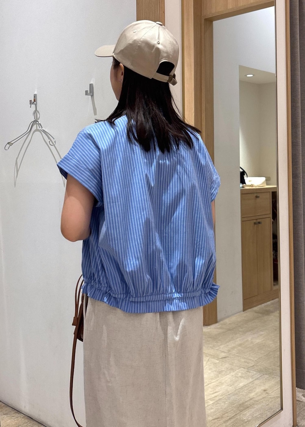 ブラック系のサンダル、ホワイト系のスカート、ブルー系のシャツ/ブラウスを着用したレディースの夏コーディネートの7枚目の写真