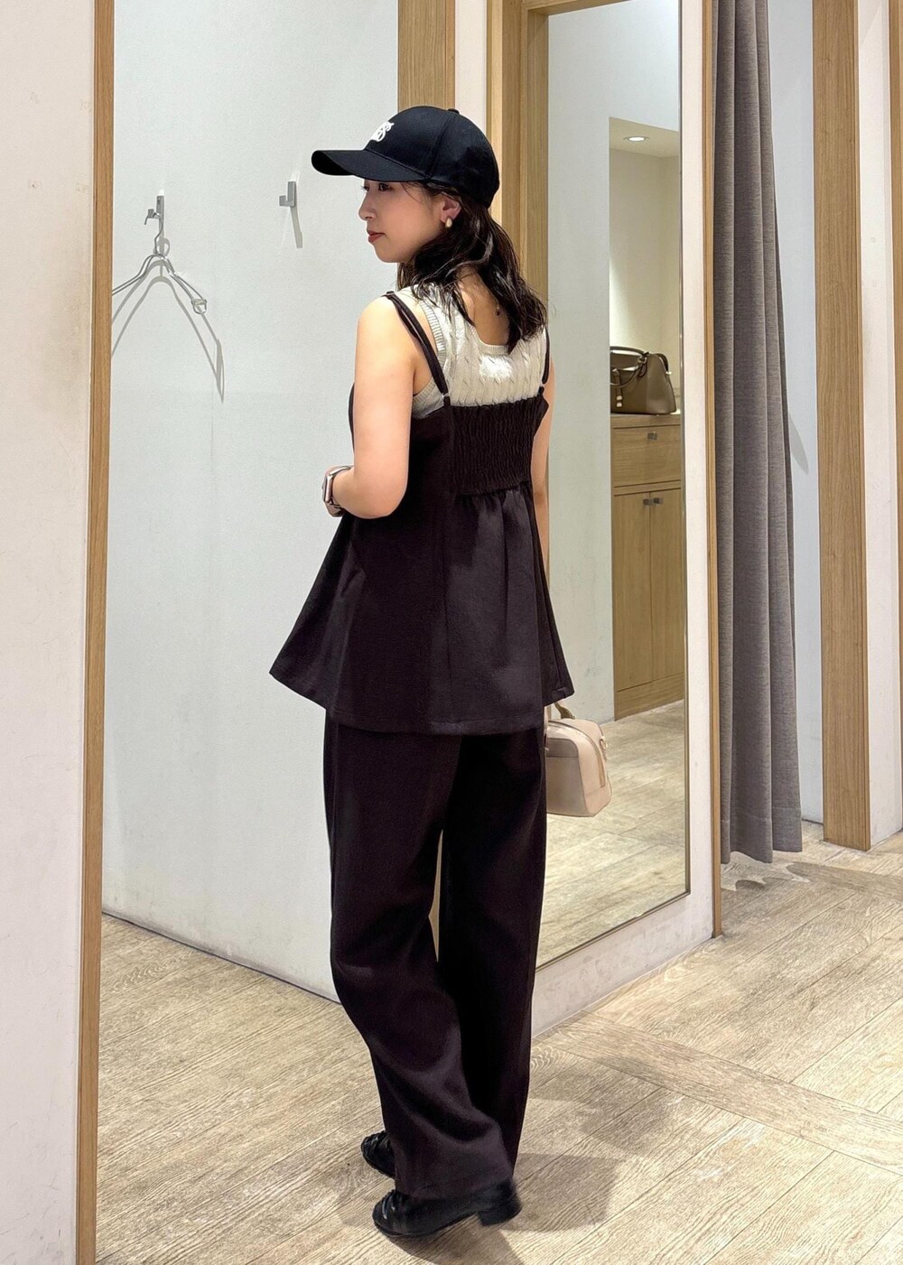 ベージュ系のボストンバッグ、ブラウン系のスラックス、ブラウン系のキャミソールを着用したレディースの秋コーディネートの3枚目の写真