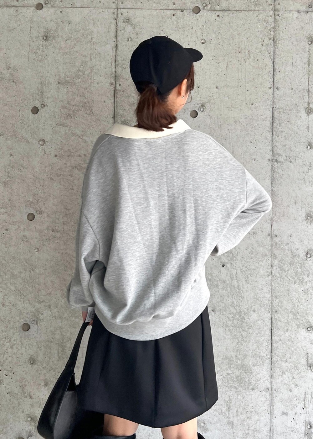 ブラック系のブーツ、ブラック系のハンドバッグ、ブラック系のスカートを着用したレディースの秋コーディネートの7枚目の写真