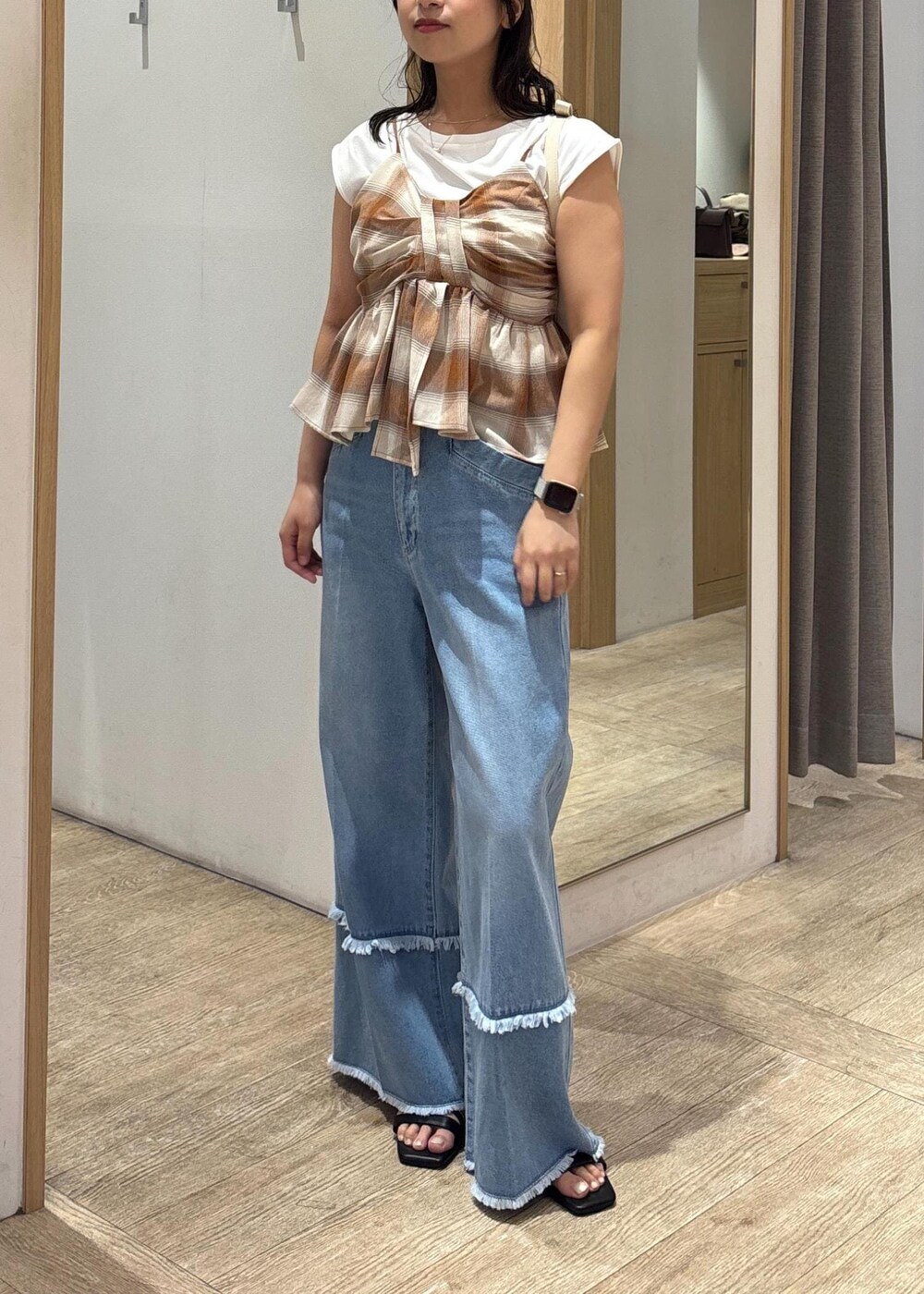 ブラック系のサンダル、ホワイト系のショルダーバッグ、ブルー系のデニムパンツを着用したレディースの夏コーディネートの9枚目の写真