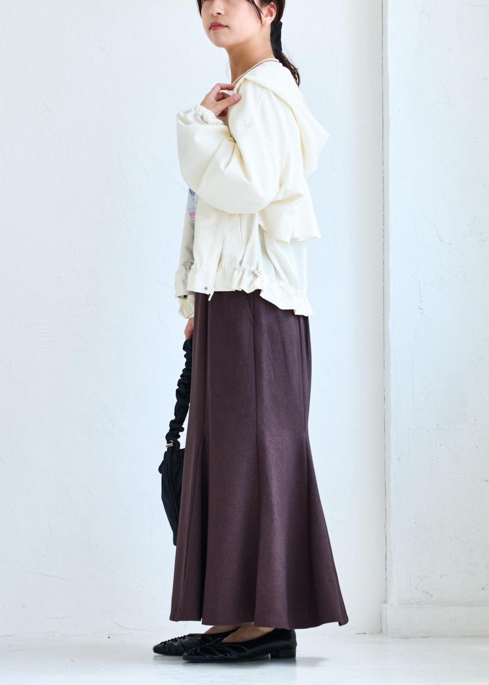 ホワイト系のショルダーバッグ、ブラウン系のスカート、ホワイト系のTシャツ/カットソーを着用したレディースの夏コーディネートの2枚目の写真