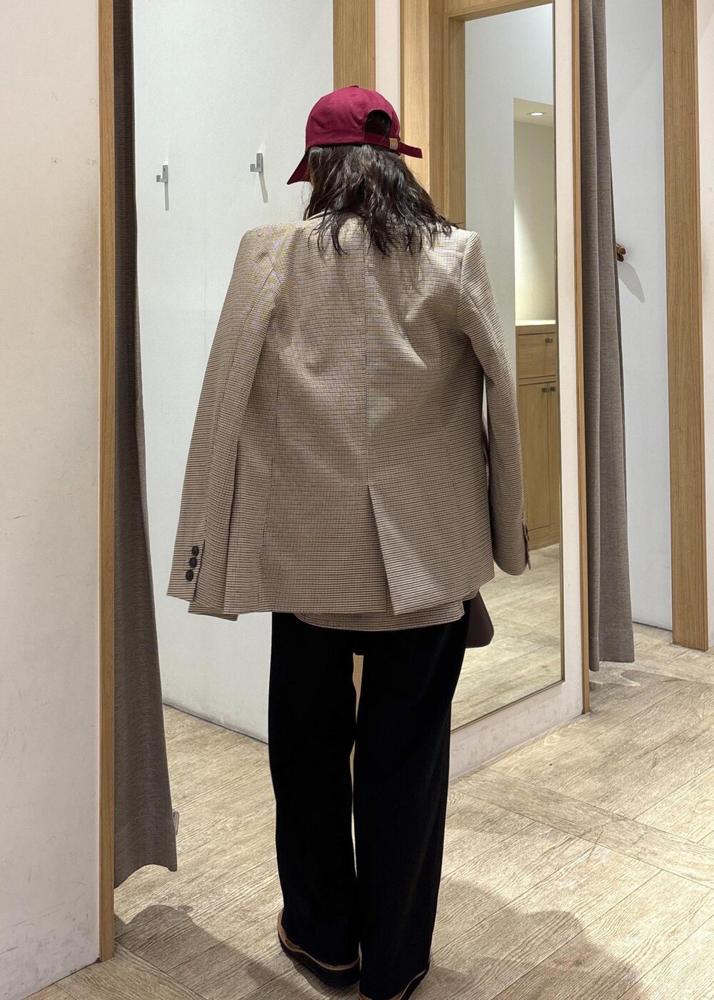 ブラウン系のショルダーバッグ、ベージュ系のテーラードジャケット、ベージュ系のキャミソールを着用したレディースの秋コーディネートの3枚目の写真