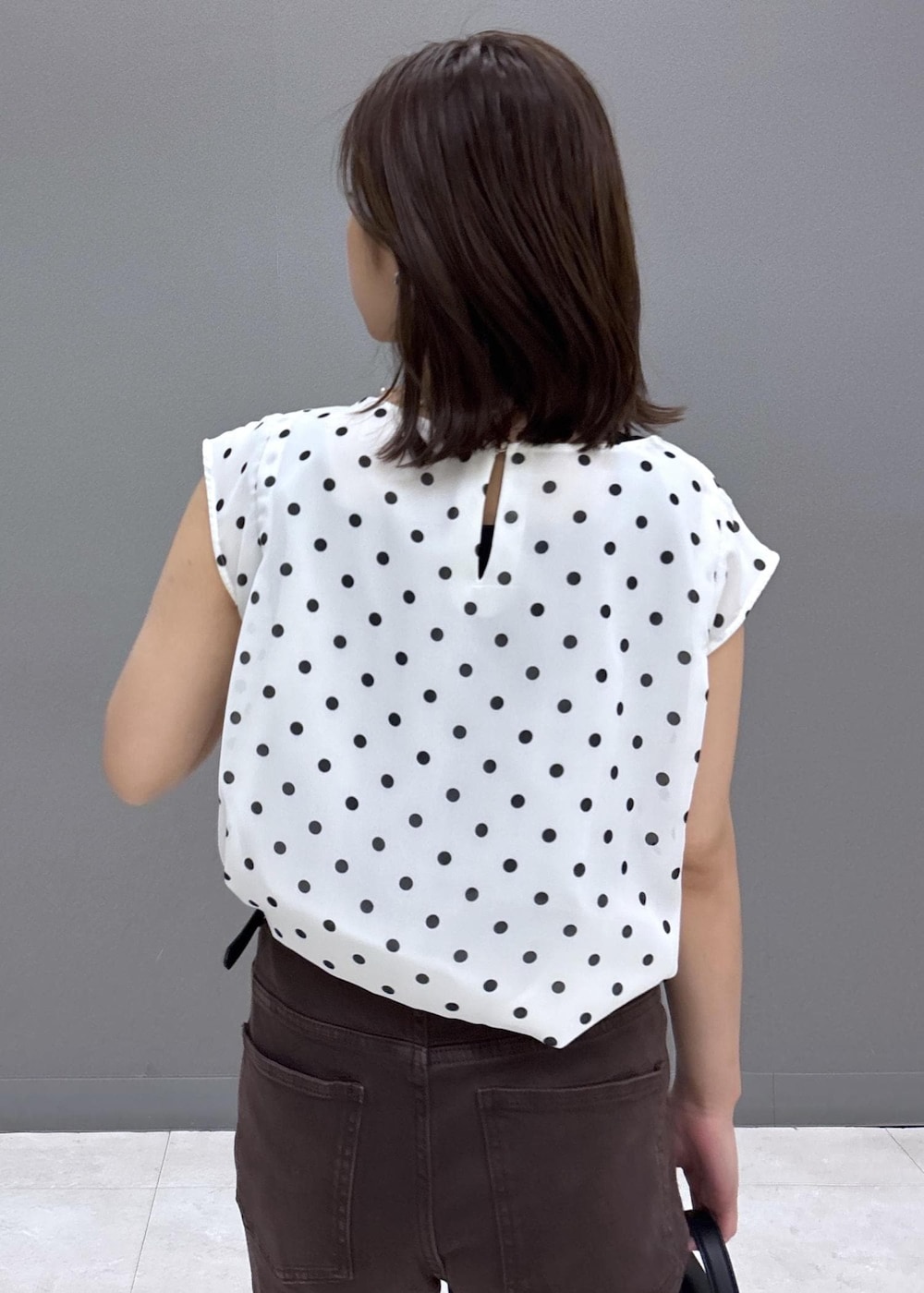 ブラック系のショルダーバッグ、ホワイト系のシャツ/ブラウス、ブラック系のパンプスを着用したレディースの夏コーディネートの7枚目の写真