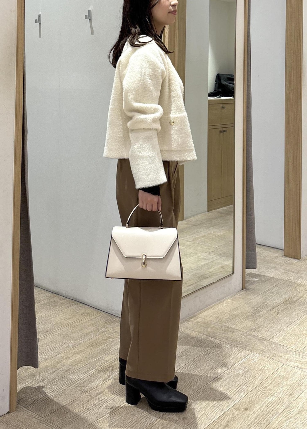 ホワイト系のカーディガン/ボレロ、ブラック系のTシャツ/カットソー、ブラック系のブーツを着用したレディースの秋コーディネートの3枚目の写真