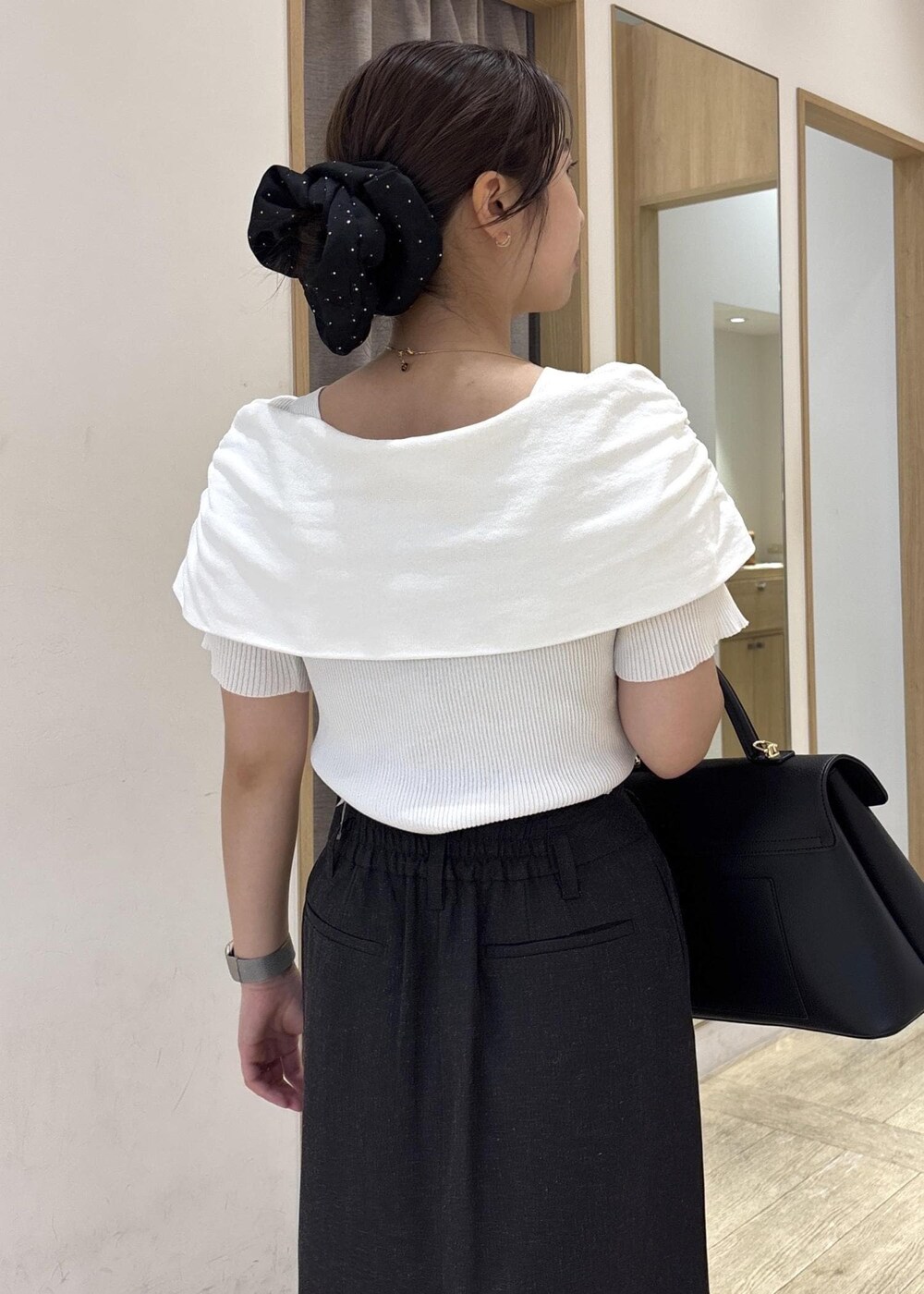 ブラック系のパンプス、ブラック系のハンドバッグ、ホワイト系のニット/セーターを着用したレディースの春コーディネートの8枚目の写真