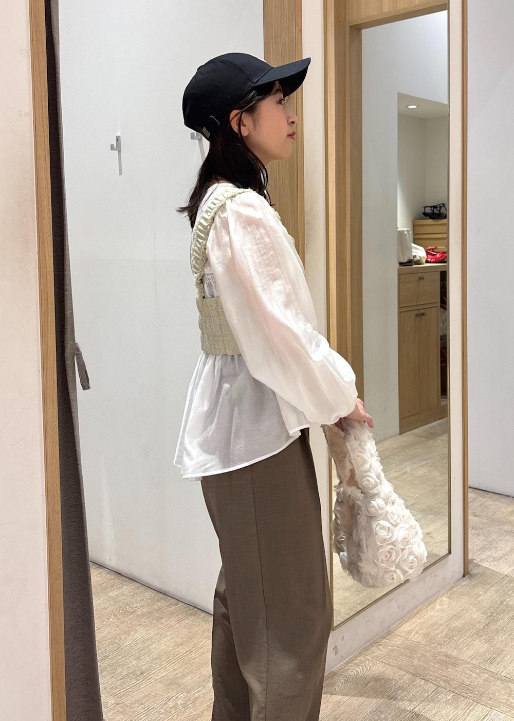 ホワイト系のシャツ/ブラウス、ブラック系のパンプス、ホワイト系のベストを着用したレディースの春コーディネートの7枚目の写真