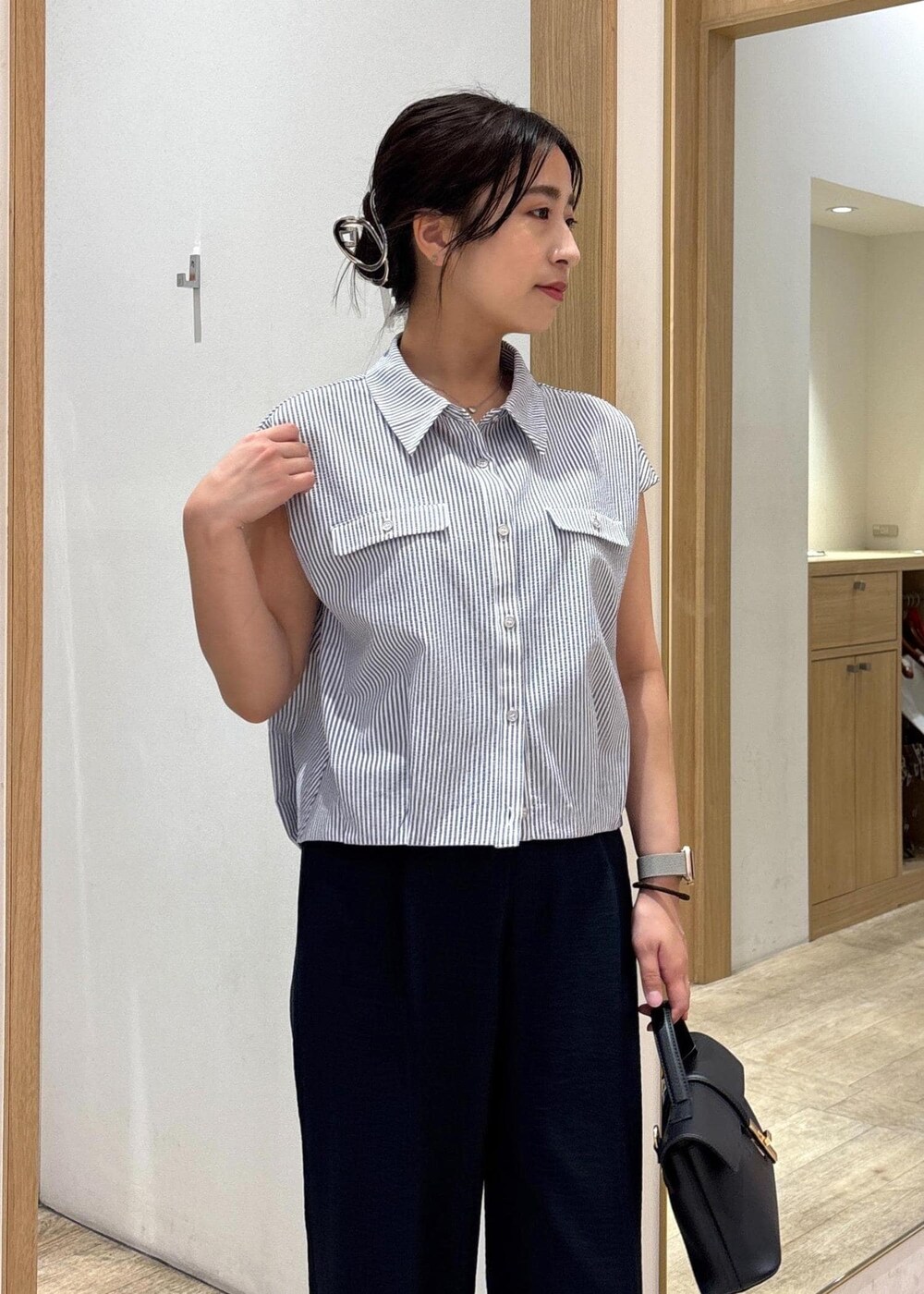 ブラック系のショルダーバッグ、シルバー系のパンプス、ブラック系のシャツ/ブラウスを着用したレディースの夏コーディネートの5枚目の写真