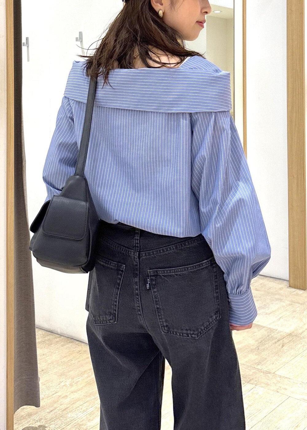 ブラック系のショルダーバッグ、ブラック系のローファー、ブルー系のシャツ/ブラウスを着用したレディースの秋コーディネートの7枚目の写真