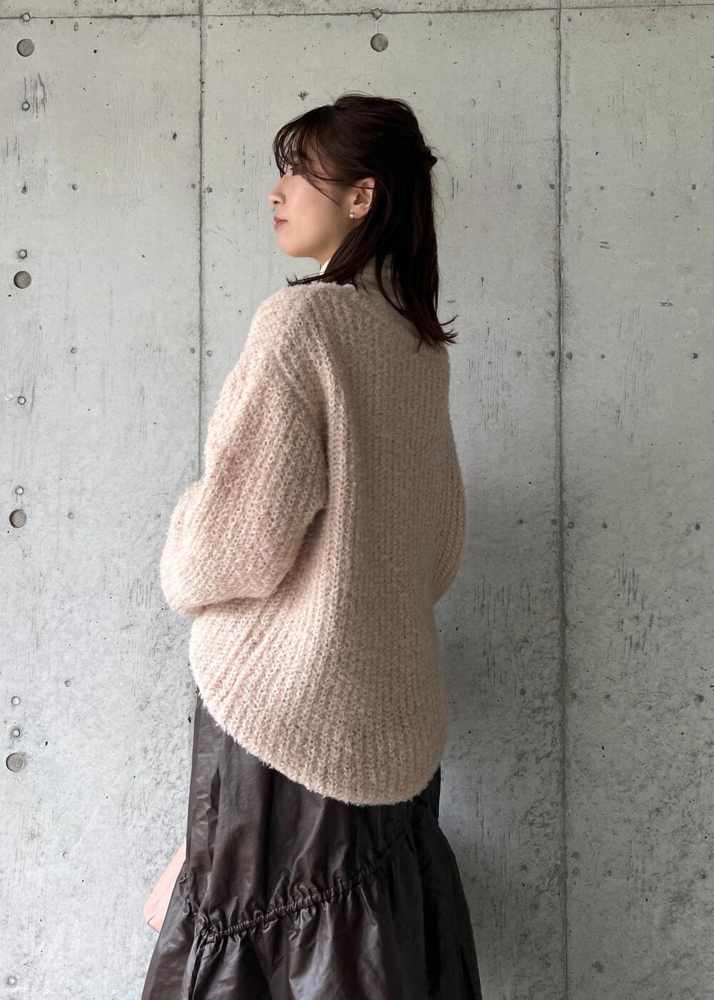 ピンク系のショルダーバッグ、ホワイト系のニット/セーター、ベージュ系のニット/セーターを着用したレディースの冬コーディネートの8枚目の写真