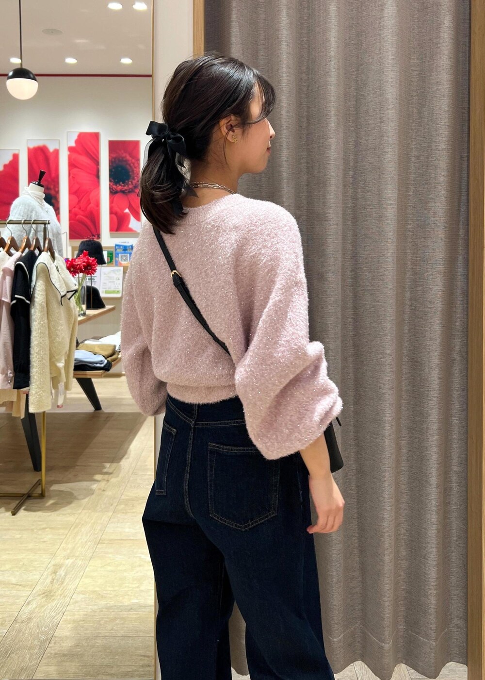ブラック系のショルダーバッグ、シルバー系のブーツ、ブルー系のデニムパンツを着用したレディースの冬コーディネートの9枚目の写真